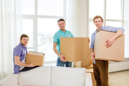 A moving team carefully carrying furniture in a modern Canary Wharf building